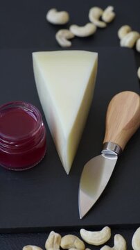 Aged cheese in a triangular block with jam, figs, and nuts. Aged cheese as a food background for your design