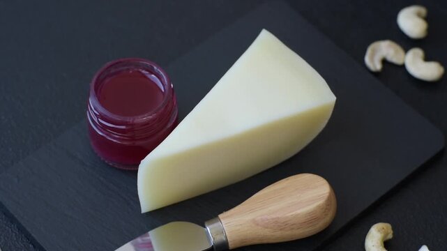 Aged cheese in a triangular block with jam, figs, and nuts. Aged cheese as a food background for your design