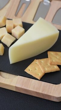Aged cheese in a triangular block with jam, figs, and nuts. Aged cheese as a food background for your design