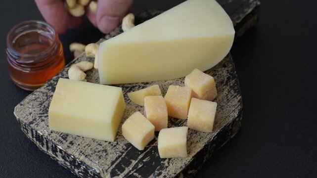 Aged cheese in a triangular block with jam, figs, and nuts. Aged cheese as a food background for your design