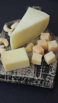 Aged cheese in a triangular block with jam, figs, and nuts. Aged cheese as a food background for your design