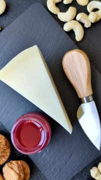 Aged cheese in a triangular block with jam, figs, and nuts. Aged cheese as a food background for your design