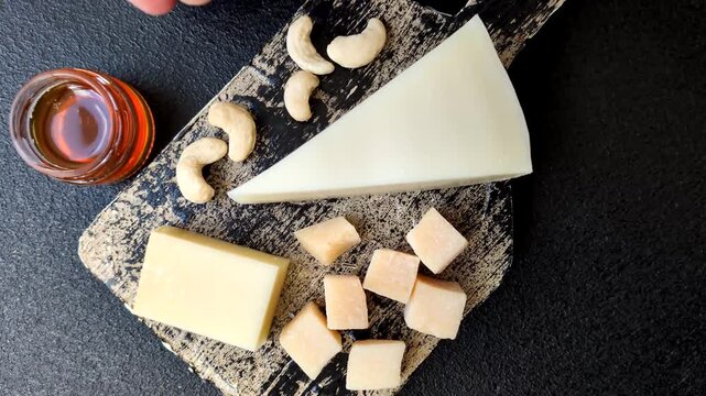 Aged cheese in a triangular block with jam, figs, and nuts. Aged cheese as a food background for your design