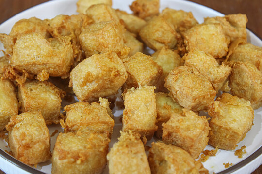 Crispy golden brown fried tofu cubes served on a white ceramic plate