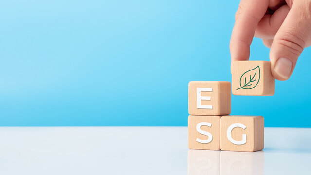 Hand placing ESG cube with green leaf for sustainability concept