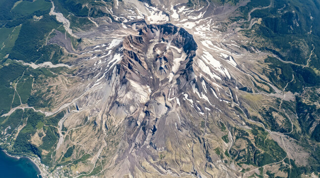 Aerial view of the Mount St. Helens crater, showcasing its dramatic post-eruption landscape and surrounding forests.