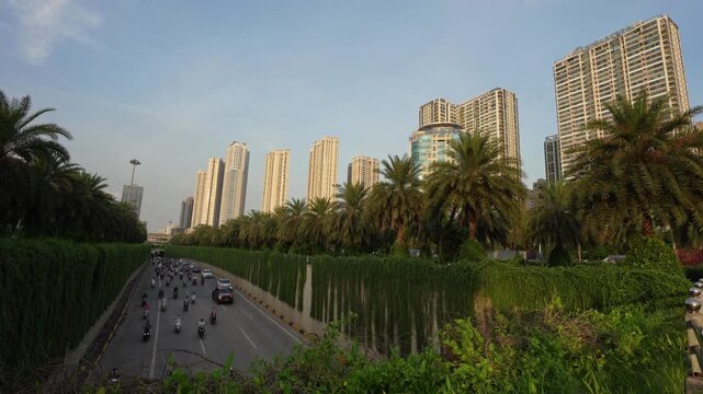 Daytime view of the Trung Hoa underpass in Hanoi with steady traffic, palm-lined embankments, and modern residential towers.