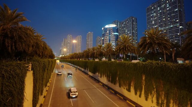 Evening view of the Trung Hoa underpass in Hanoi featuring illuminated roadways, palm-lined walls, and modern urban architecture.