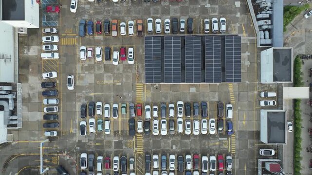 Top-down aerial view of a crowded parking lot with rows of parked vehicles and rooftop solar panels in Hanoi.