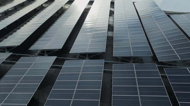 Close aerial view of rooftop photovoltaic panels arranged in rows for large-scale solar power generation.