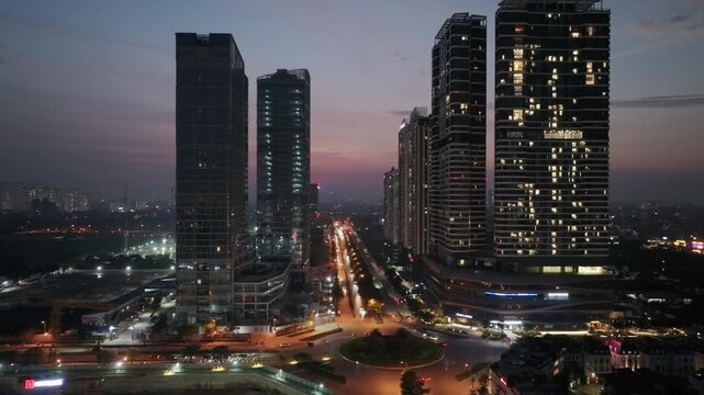 Twilight cityscape of the Diplomatic Corps area along Hoang Minh Thao Street with illuminated towers and urban traffic.