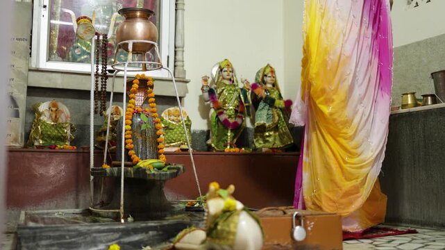 hindu religious ceremony with woman offering prayers to lord shiva inside shrine