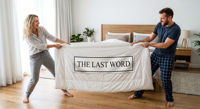 Couple in a playful argumentative mood tugging over a duvet labeled &ldquo;THE LAST WORD&rdquo; in a bright modern bedroom