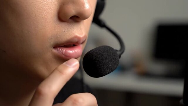 Close up of a customer service representative speaking through a headset microphone in a modern office setting.