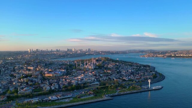 Istanbul cityscape with the iconic Sultan Ahmed Mosque and Hagia Sophia blending historical architecture with the modern Bosphorus skyline. speed ramp, time lapse aerial view ascending raise up