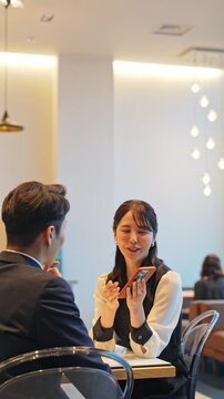レストランでスマホを見るカップル