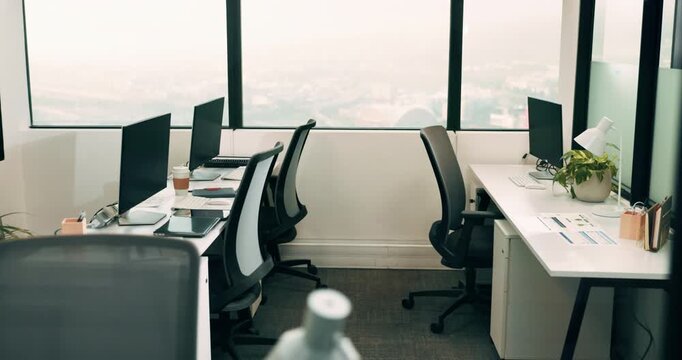 Empty, office and coworking space with computer for business, workflow and efficiency. Window, desk and technology in agency with furniture, workplace setup or interior for professionalism in company