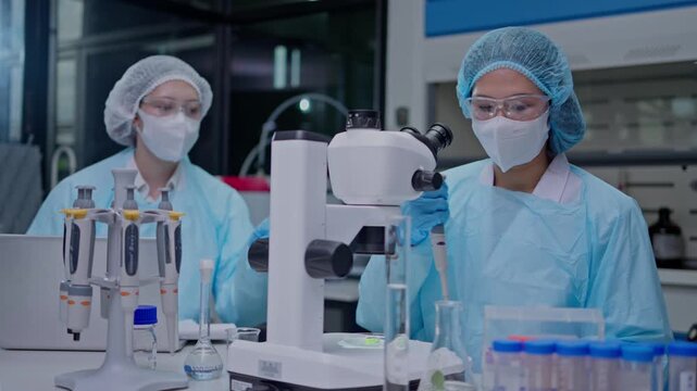 Laboratory researchers conducting experiments with microscopes in a modern science facility