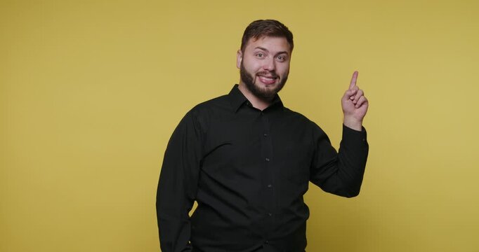 Man gives instructions in a studio with a plain yellow background during a creative session in the early afternoon