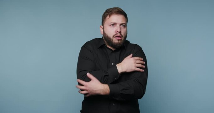 Man shows different reactions to feeling cold in a studio setting at daytime