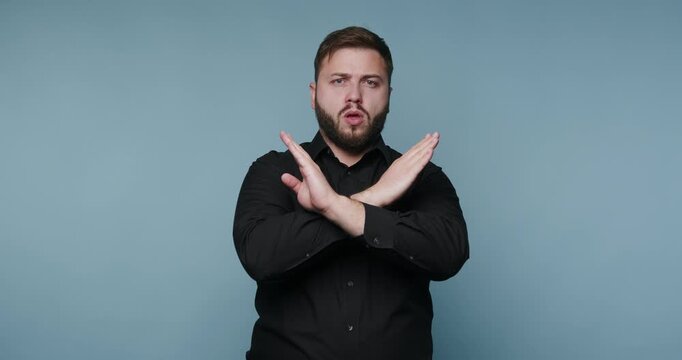 Man performs sign language gestures in a studio with a plain blue background