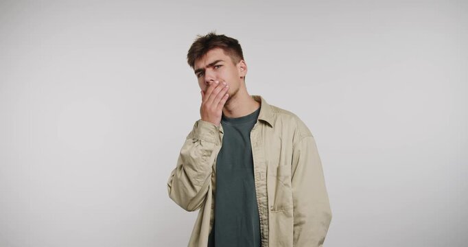 Man thinks and reacts with different expressions in a simple studio setting during a creative activity