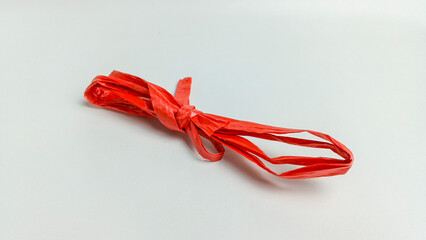 Red raffia rope over white background. raffia rope is used for tying. © Aprilianti