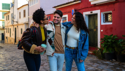 Fototapeta premium Group of diverse friends walking on a cobblestone street, embracing each other and smiling, enjoying their time together in an old town or city environment