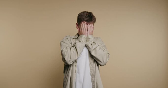 Person covers face with hands in four frames showing a range of emotions in simple setting