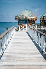 Obraz premium Luxury tropical resort vacation concept with a wooden pier extending to oceanfront overwater bungalows on a sunny summer day