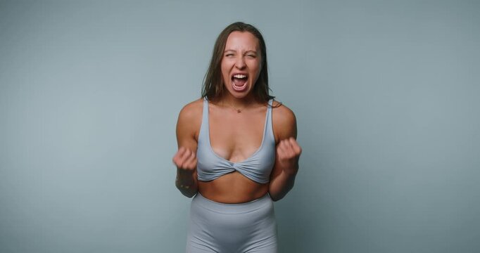 Woman shows emotions with strong facial expressions in a photo shoot at a studio in the afternoon