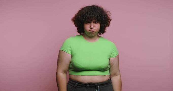Display of emotions through four expressions by a person wearing a green shirt against a pink background