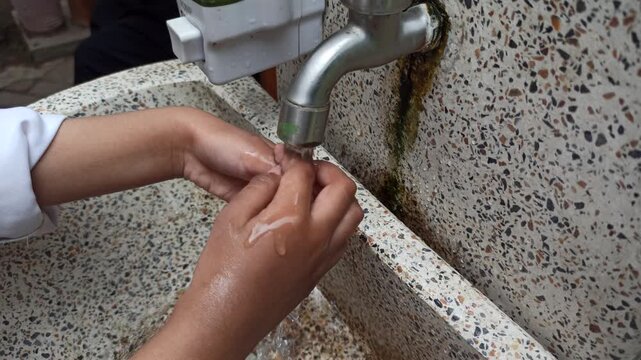 Children practicing proper handwashing techniques with clean water and soap as part of personal hygiene education and disease prevention efforts.