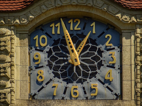 Close-up of a historic church tower clock with golden hands and numbers, conceptual image of Swiss precision and time management