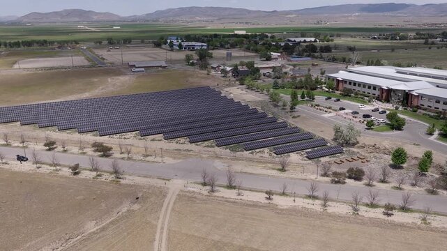 Panning aerial footage shows a sprawling solar panel farm next to an office building in Minden, Nevada, showcasing the future of renewable green energy production in a rural landscape