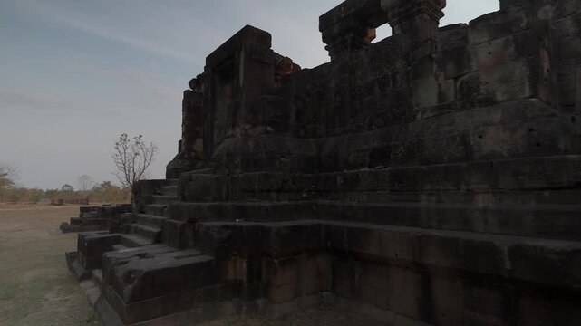 Shot of Prasat Hong Nang Sida in Laos, showing ancient stone blocks, weathered walls and Khmer temple architecture.