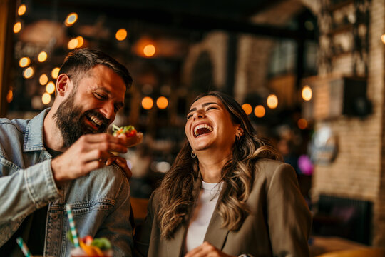 Happy couple enjoying a night out laughing and dining