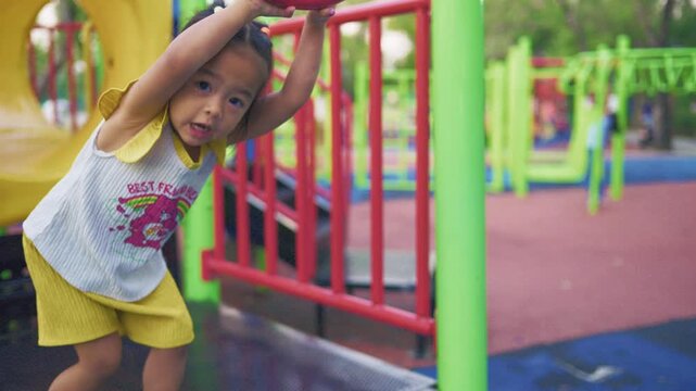 Adorable little kindergarten girl enjoy climb in playground outdoor park relax