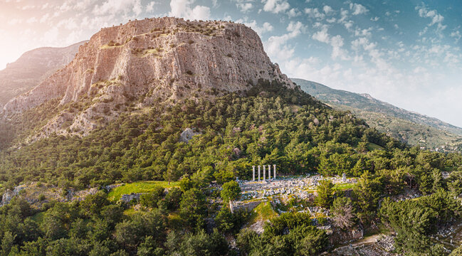 Sunbeam illuminating the ancient Greek city ruins of Priene and the remaining columns of the Temple of Athena Polias in Turkiye