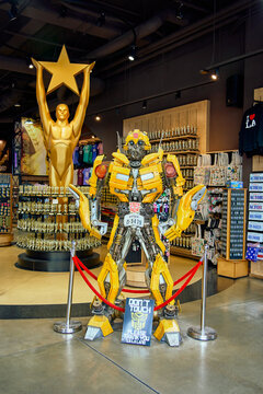 Life-size yellow Bumblebee Transformers statue and a large golden Hollywood star award figure inside a souvenir store.