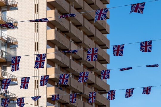 British flags hang between Benidorm Spain apartment balconies, adding travel color to highrise facade, blue sky and resort city detail