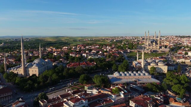 aerial drone panorama of Edirne cityscape at sunset, revealing the famous imperial Selimiye and Uc Serefeli Ottoman mosques with high minarets and stone domes, Turkey