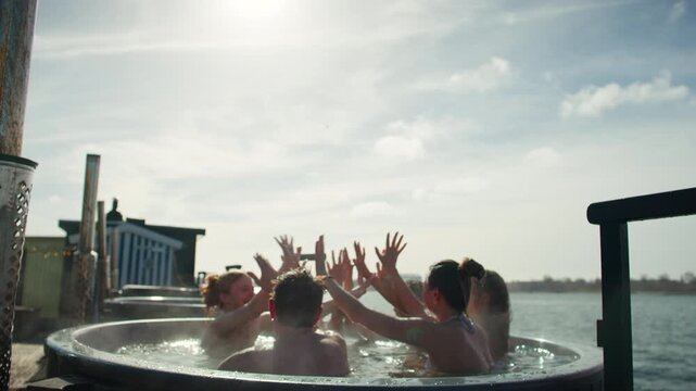 Celebration and sunshine bring friends together in an outdoor hot tub at the waterfront