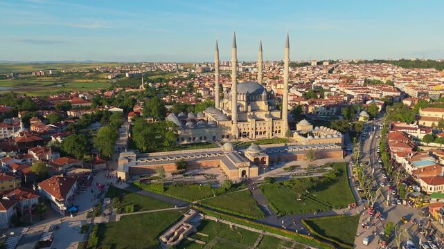 wide aerial drone panorama of Edirne cityscape at sunset, revealing the famous imperial Selimiye and Uc Serefeli Ottoman mosques with high minarets and stone domes, Turkey