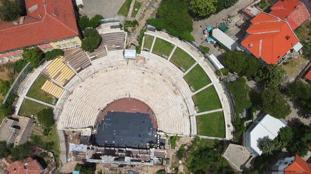 aerial drone top down  the ancient Roman Theatre of Philippopolis and traditional houses with red roofs in the old town hill district of Plovdiv, Bulgaria