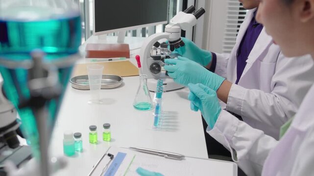 Asian male and female scientists are conducting laboratory research on disease treatments, working in medical chemistry and developing vaccines.