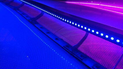 Blue and magenta LED light bars illuminating a textured surface. Creating a futuristic neon glow. © nisara