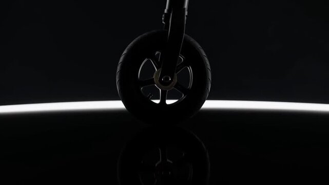 Electric scooter wheel rotating on reflective black surface in studio.