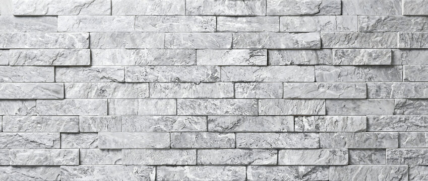 Stone wall texture background with white grey marble brick cladding panels in a stacked ledger pattern
