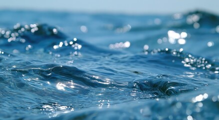 Sunlit ocean waves ripple with sparkling light on a clear day